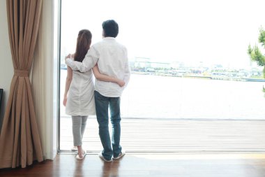 Pencerenin önünde duran bir çift.