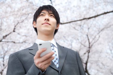 Parkta akıllı telefon kullanan iş adamı 