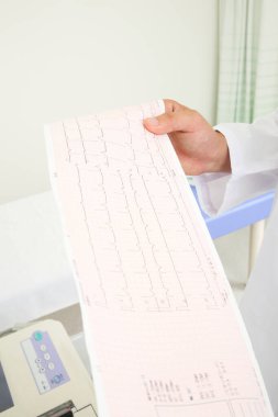 Doktor hastanede hastanın elektrokardiyogramını (EKG) kontrol ediyor..