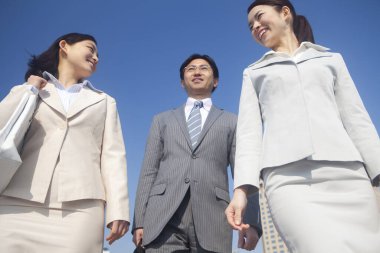 Yakışıklı Japon işadamının portresi. Sokakta poz veren iki iş kadını.