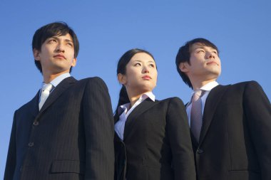 Üç iş adamı yukarı bakıyor.