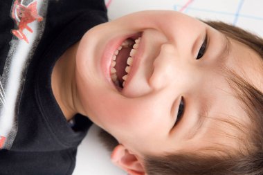 Yakından - gülümseyen küçük bir çocuğun portresi.