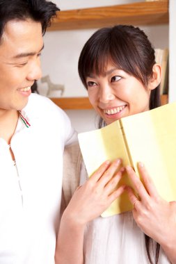 Mutlu çift oturma odasında kitap okuyor.