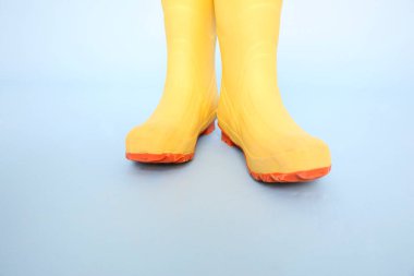 Mavi arka planda sarı lastik çizmeler