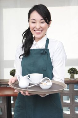 Garson kafede kahve servisi yapıyor.