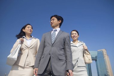 Yakışıklı Japon işadamının portresi. Sokakta poz veren iki iş kadını.