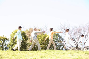 Parktaki büyük aile alıştırma yapıyor. 