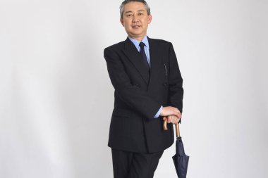 Japon işadamı şemsiye tutuyor, stüdyo fotoğrafı. 