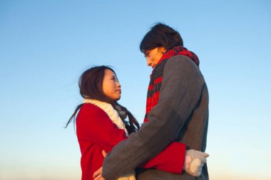 Birbirine aşık genç Asyalı bir çiftin açık hava portresi.