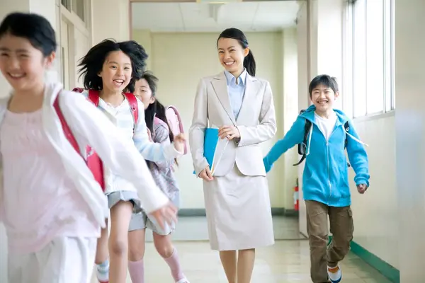 学校の廊下で教師と一緒に幸せな学校の子供たち — ストック写真