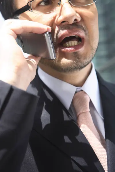 携帯電話で話すアジアのビジネスマンのクローズアップポートレート — ストック写真