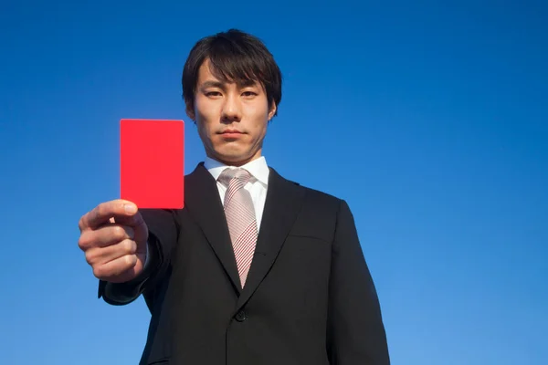 young man in suit showing empty red  card