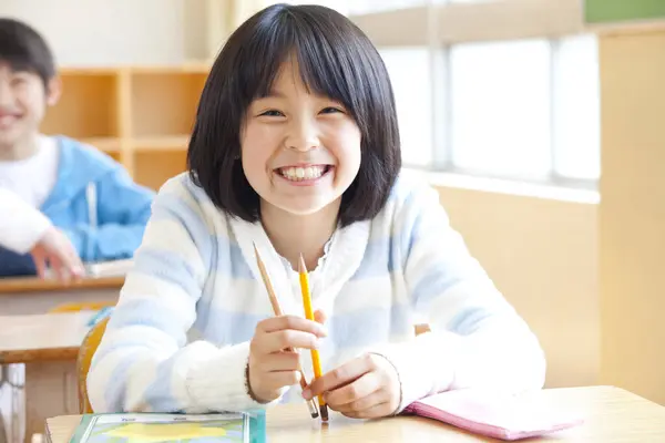 Jong Japans Schoolmeisje Studeren Aan Bureau Rechtenvrije Stockfoto's