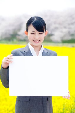 Beyaz boş afişi olan genç Asyalı kadın.