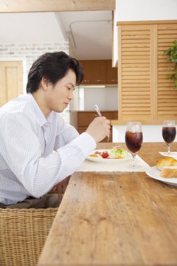 Adam mutfakta kahvaltı yapıyor.