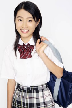 Beyaz arka planda okul üniforması olan Asyalı kız. 