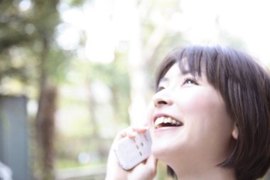 Asyalı kadın cep telefonu açık havada kullanarak