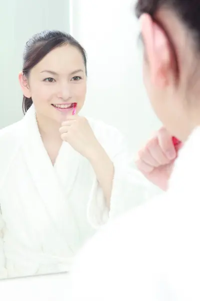 woman brushing teeth in bath