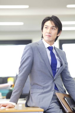 Ofiste poz veren takım elbiseli bir adam. 