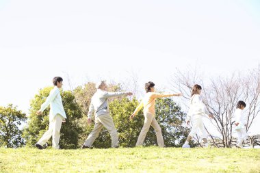 Parktaki büyük aile alıştırma yapıyor. 