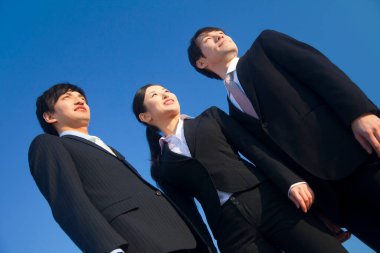 Üç işadamı dışarı bakıyor. 