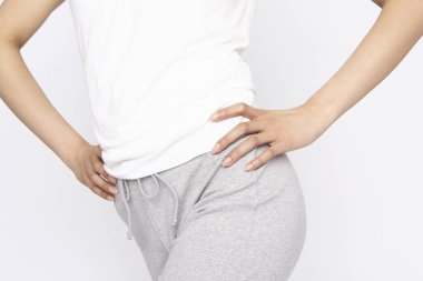 Beyaz gömlekli kadın beyaz arka planda egzersiz yapıyor, kilo kaybı var.