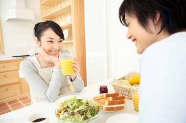 Asyalı bir aile evde öğle yemeği yiyor. 