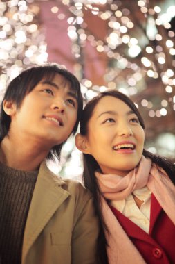 Genç Asyalı çift dışarıda poz veriyor.