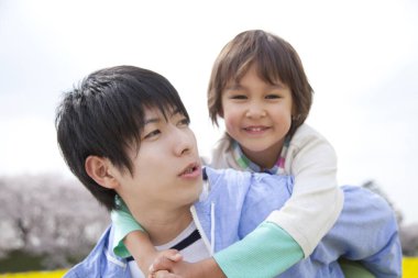 Asyalı aile babası ve oğlu parkta.