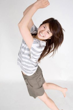 Genç Asyalı kız atlıyor, stüdyo fotoğrafı.