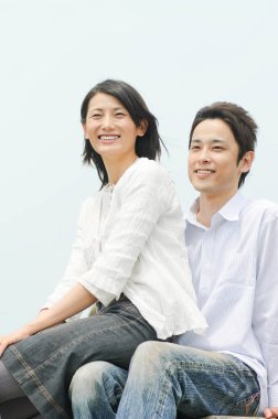 Parkta gülümseyen Asyalı çift. 