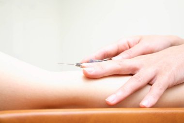 Doktor hastanın damarından kan alıyor..