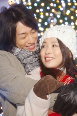 Noel pazarında birbirine aşık Asyalı mutlu bir çiftin portresi