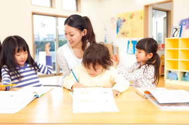 öğretmen sınıfta çocuklu 