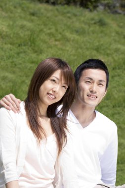 Mutlu Asyalı çift parkta dinleniyor.