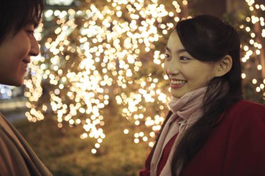 Şehirdeki Asyalı çift ışıklara karşı. 