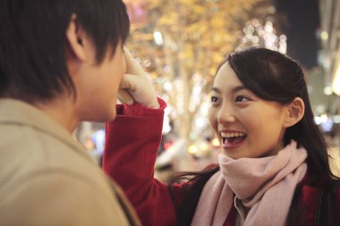 Genç Asyalı bir çiftin Noel panayırında birbirine aşık portresi. 