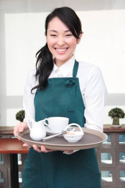 Garson kafede kahve servisi yapıyor.
