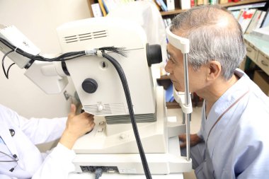 Göz doktoru hastanede bir hastayı muayene ediyor.