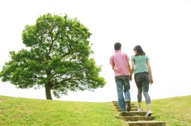 Mutlu bir ailenin parkta yürüyüşünün arka görüntüsü 