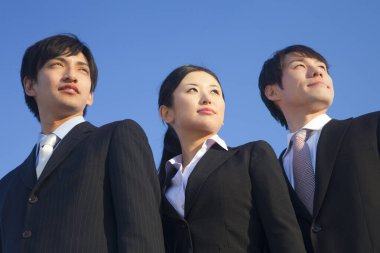 İş ekibi mavi gökyüzünün önünde duruyor.