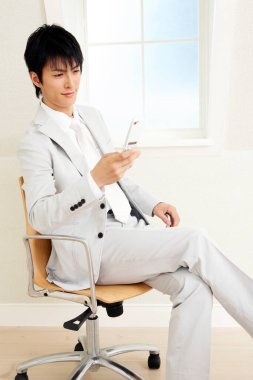 Ofiste cep telefonu kullanan bir işadamı 