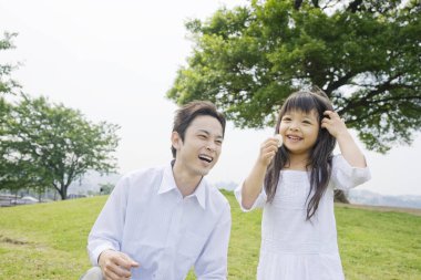 Genç Asyalı aile parkta eğleniyor.