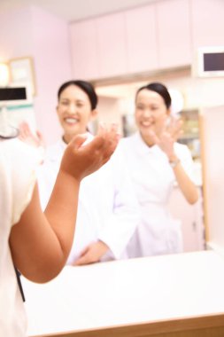 İki gülümseyen kadın müşteriye el sallıyor