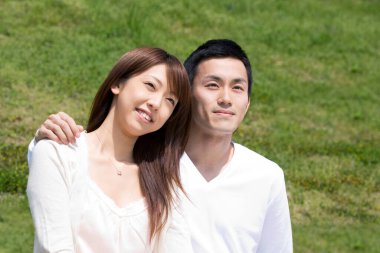 Mutlu Asyalı çift parkta dinleniyor.