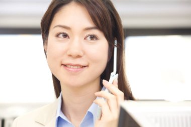 Takım elbiseli bir kadın cep telefonuyla konuşuyor.