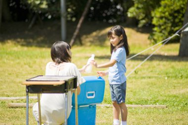 Kadın ve kız açık hava pikniğinin tadını çıkarıyor.
