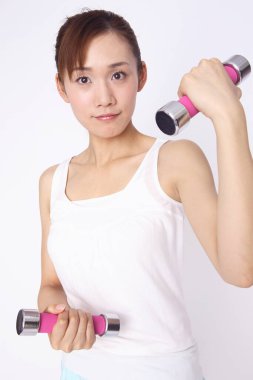 Beyaz arka planda izole halterlerle egzersiz yapan Asyalı kadın. 