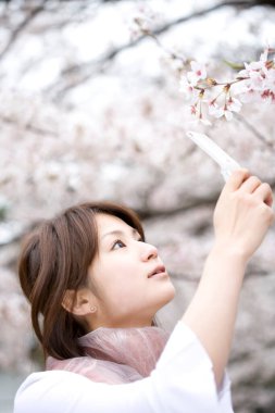 Kiraz çiçekleri olan Asyalı kadın.