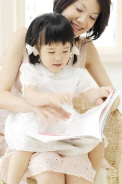 Asyalı anne-kız kitap okuyorlar.